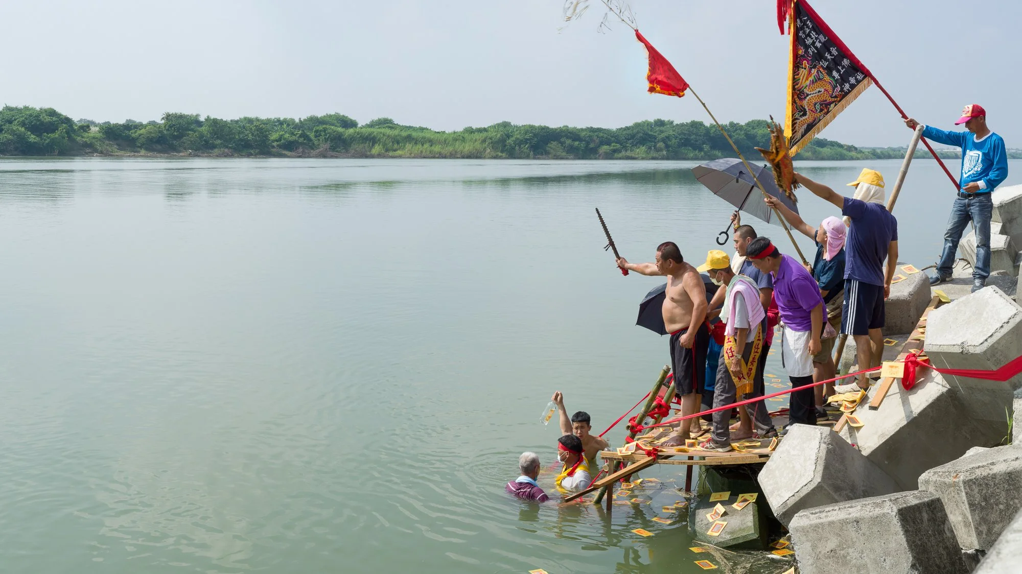Villagers conduct a sacred ceremony by the Zéngwén river, inviting spirits to guard and protect their community.

Sai-káng, Tainan, Taiwan 2022.