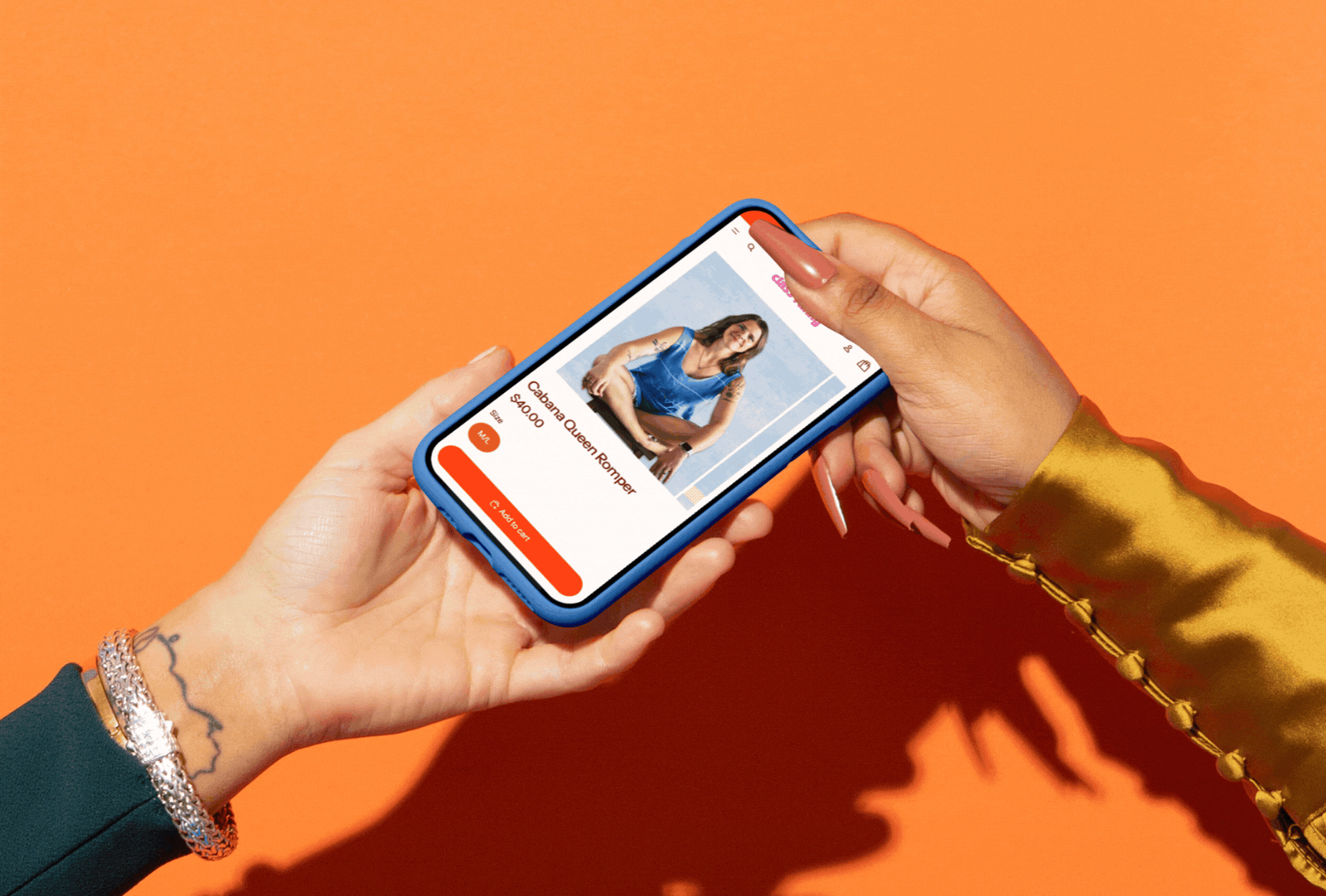 Person holding a smartphone displaying an online shopping app with a women's blue blouse, labeled 'Cabanam Queen Romper,' priced at $40.00, against an orange background.