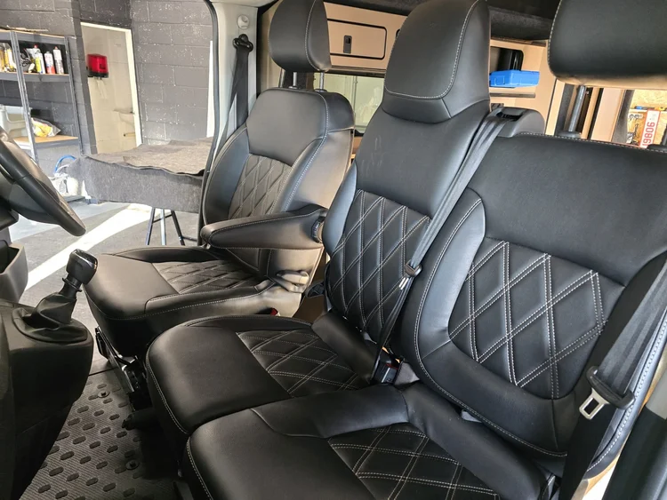 Diamond stitched front captain seats inside the Fiat Talento camper conversion.