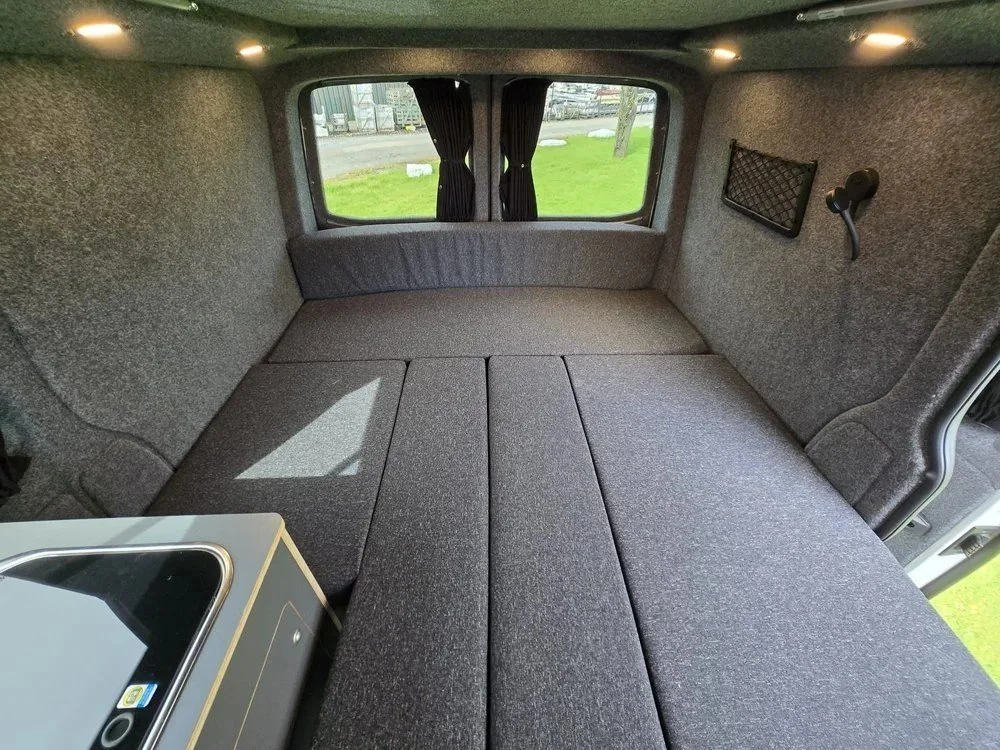 Spacious bed layout within bespoke campervan conversion