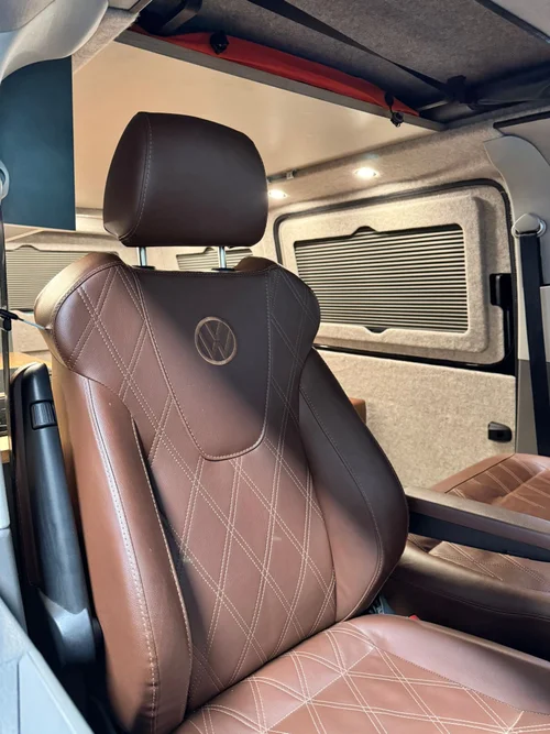 Bespoke VW T6.1 campervan interior with oak cabinetry and swivel seat