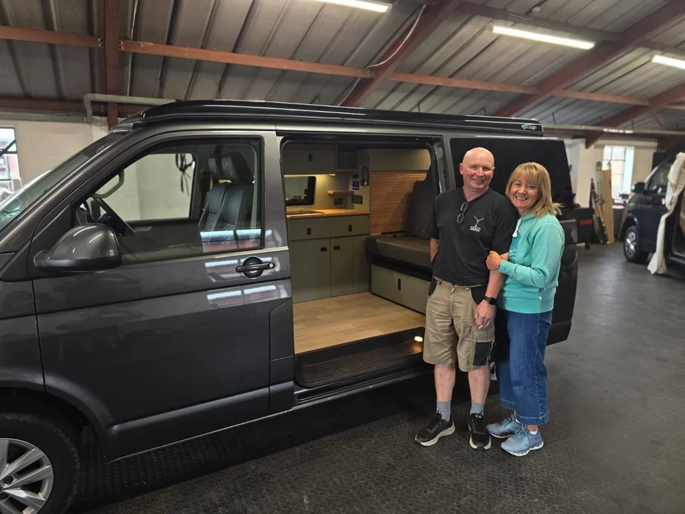 Custom camper van conversion rock and roll bed with integrated storage system