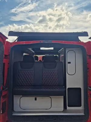 Custom red and black campervan upholstery in a Vivaro conversion