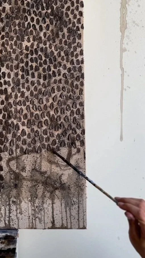 An artist creating a pointillist-style painting on canvas, depicting a flock of birds, using a paintbrush held in their hand.