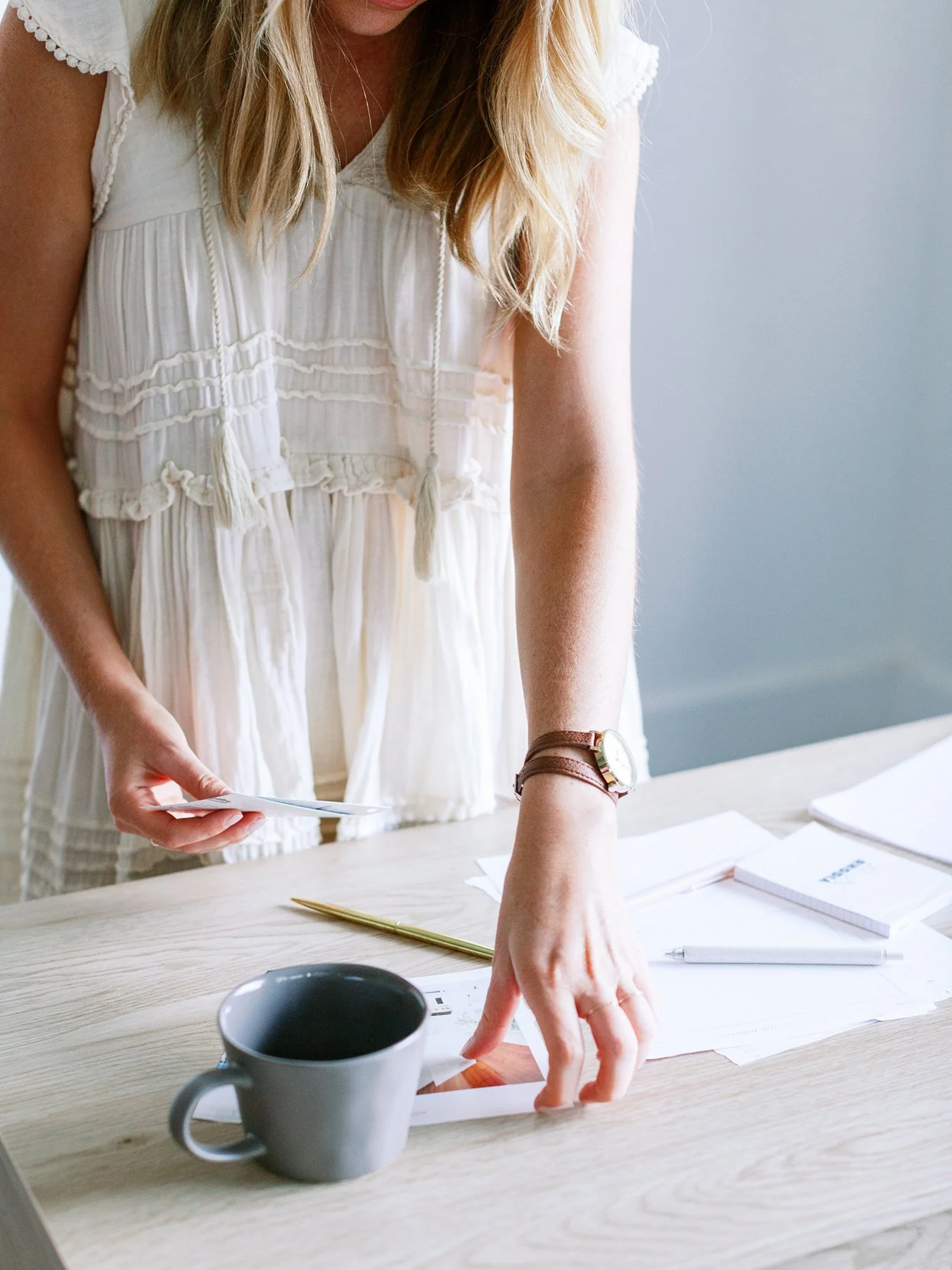 Woman reviewing papers at a desk while working through brand strategy decisions.