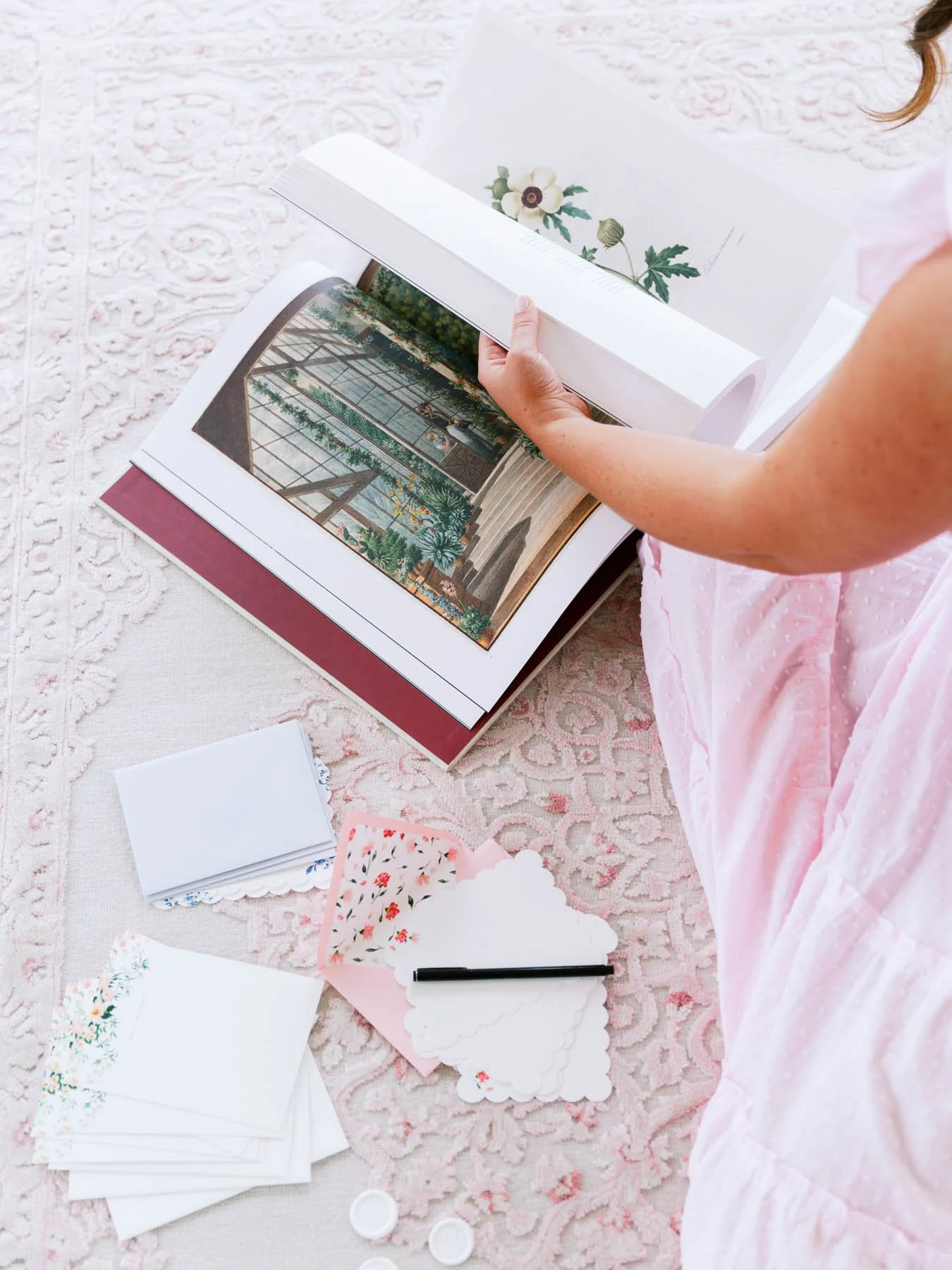 Woman holding an open book while sitting on the floor—creative moment for solo entrepreneurs.