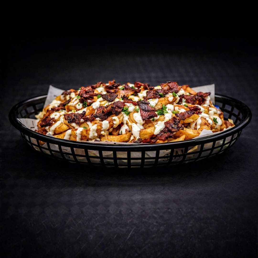 Basket of loaded Curly fries topped with bacon bits, drizzled with ranch sauce, chopped green onions, and cheese.
