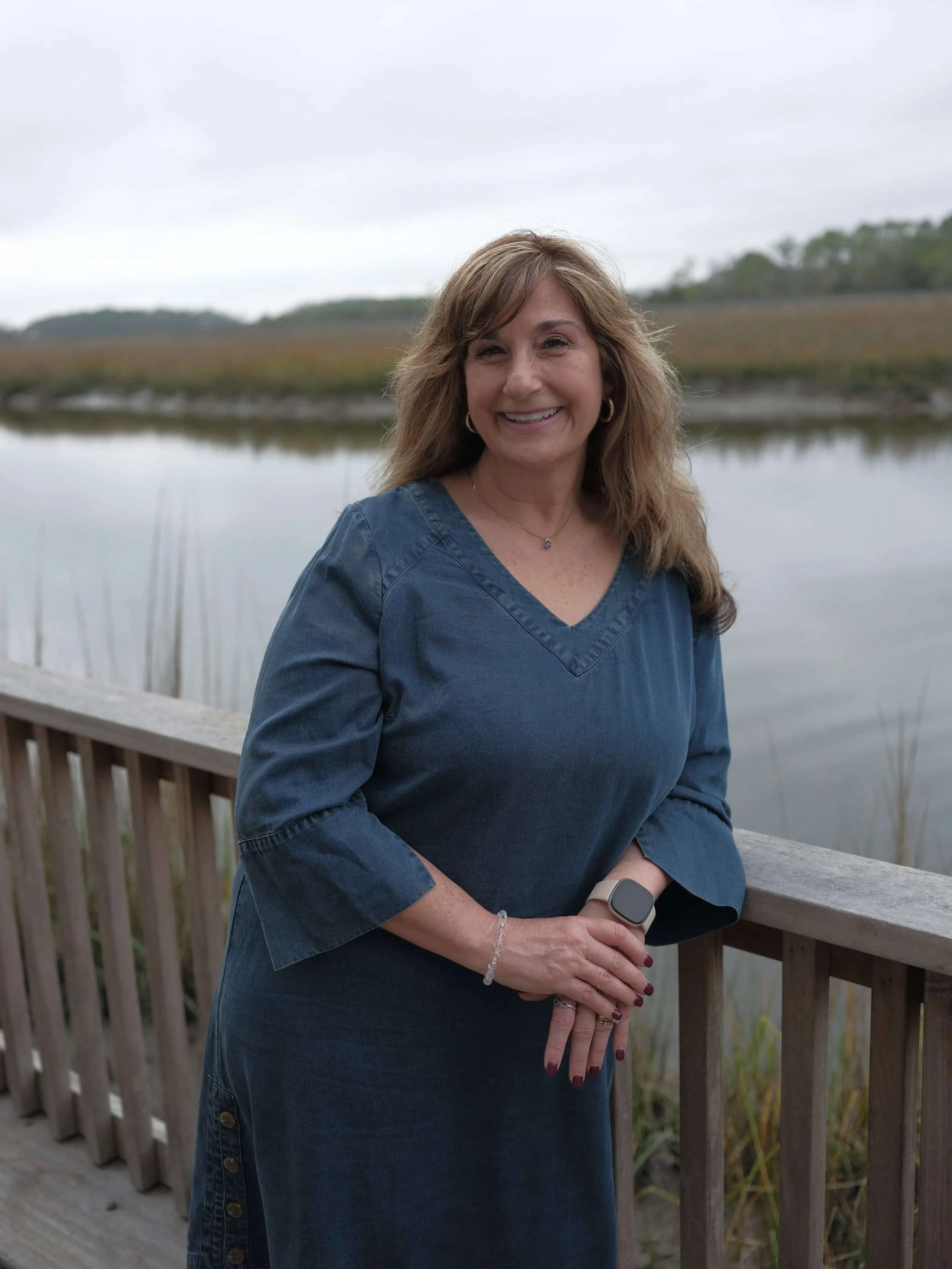 Therapist Stacy Albarran smiling outdoors near the water.