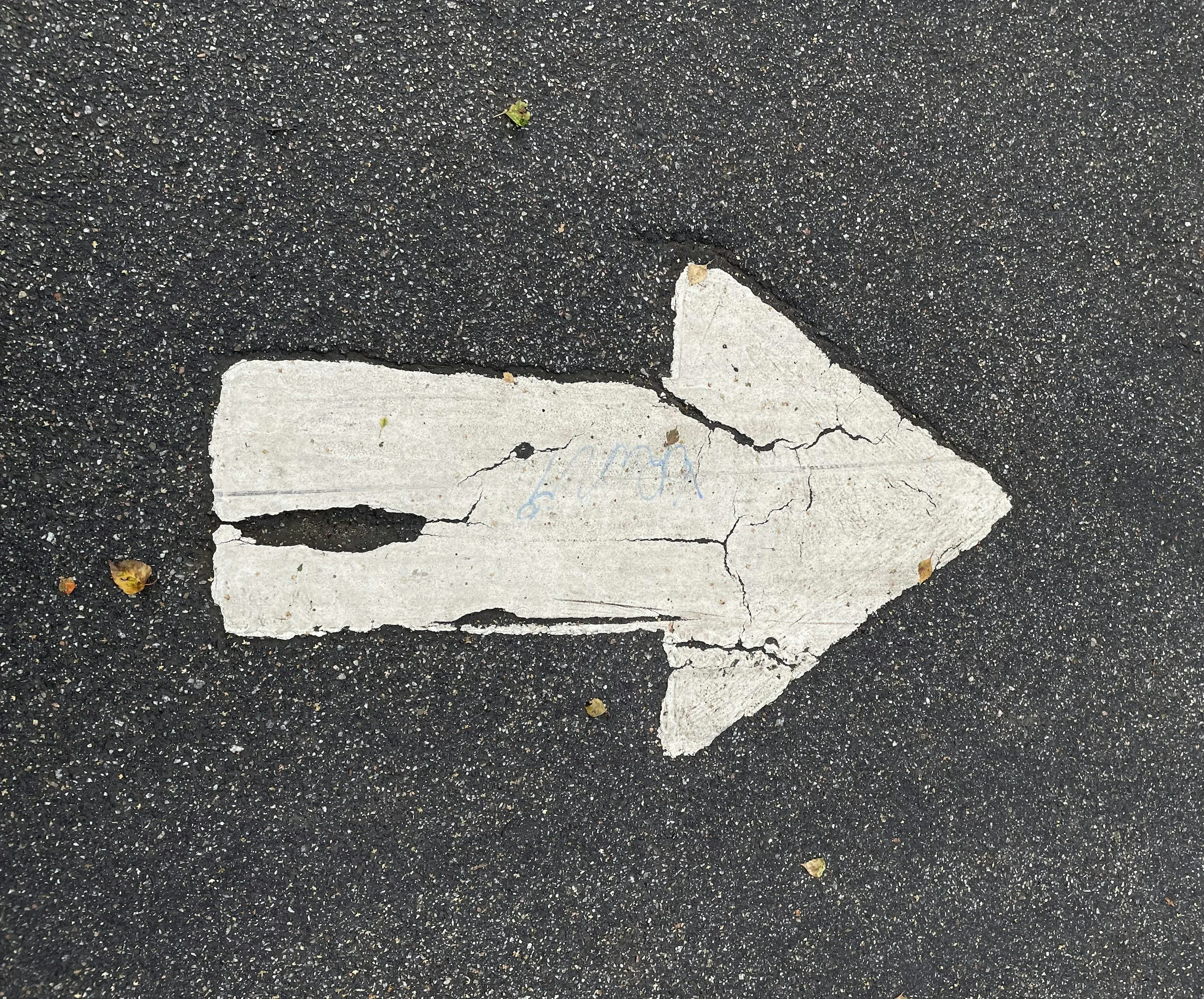 white arrow that appears to be on a blacktop road