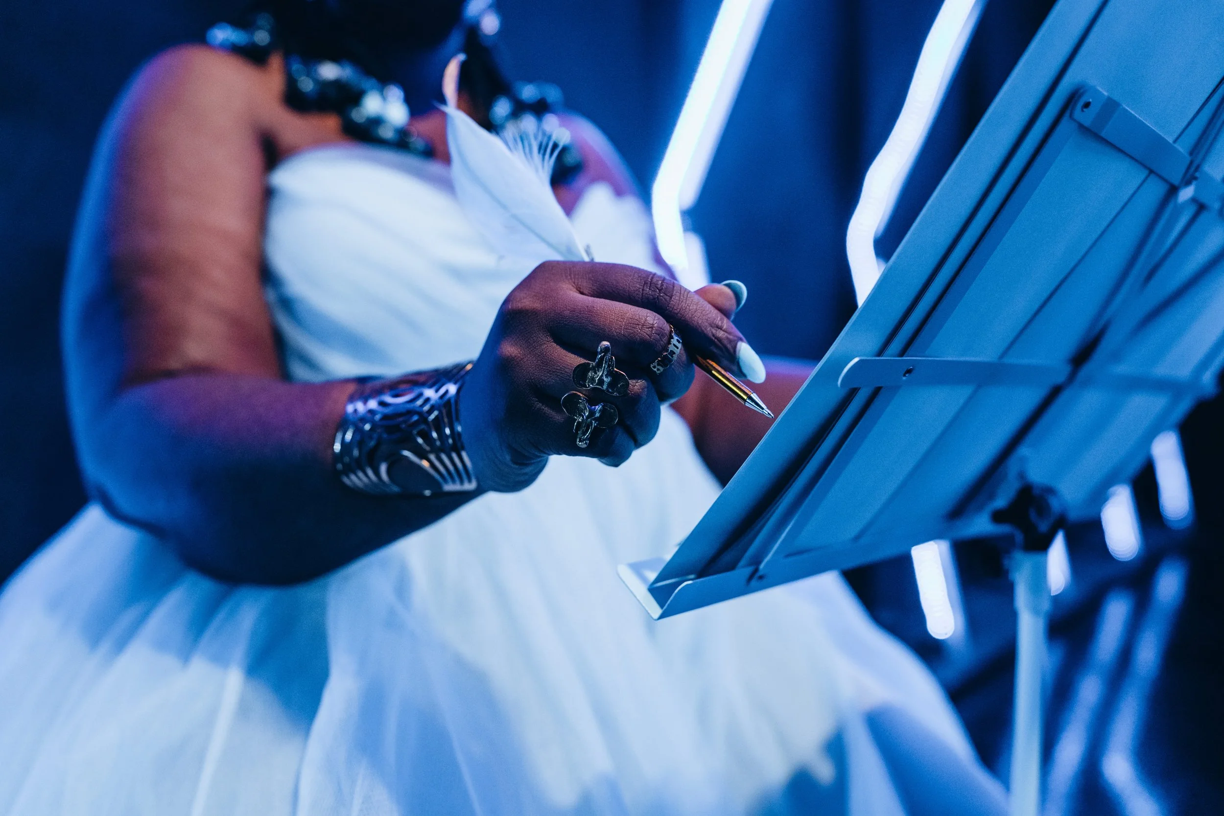 Dom Jones writes music in a princess dress the color of the clearest blue sky.