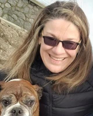 Client, Mokie Burnham, smiling and reviewing a personal training program with Duncan Rumak, praising Precision Personal Training for helping her and her husband achieve their fitness and athletic goals, including kickboxing, boxing, and muscle build.