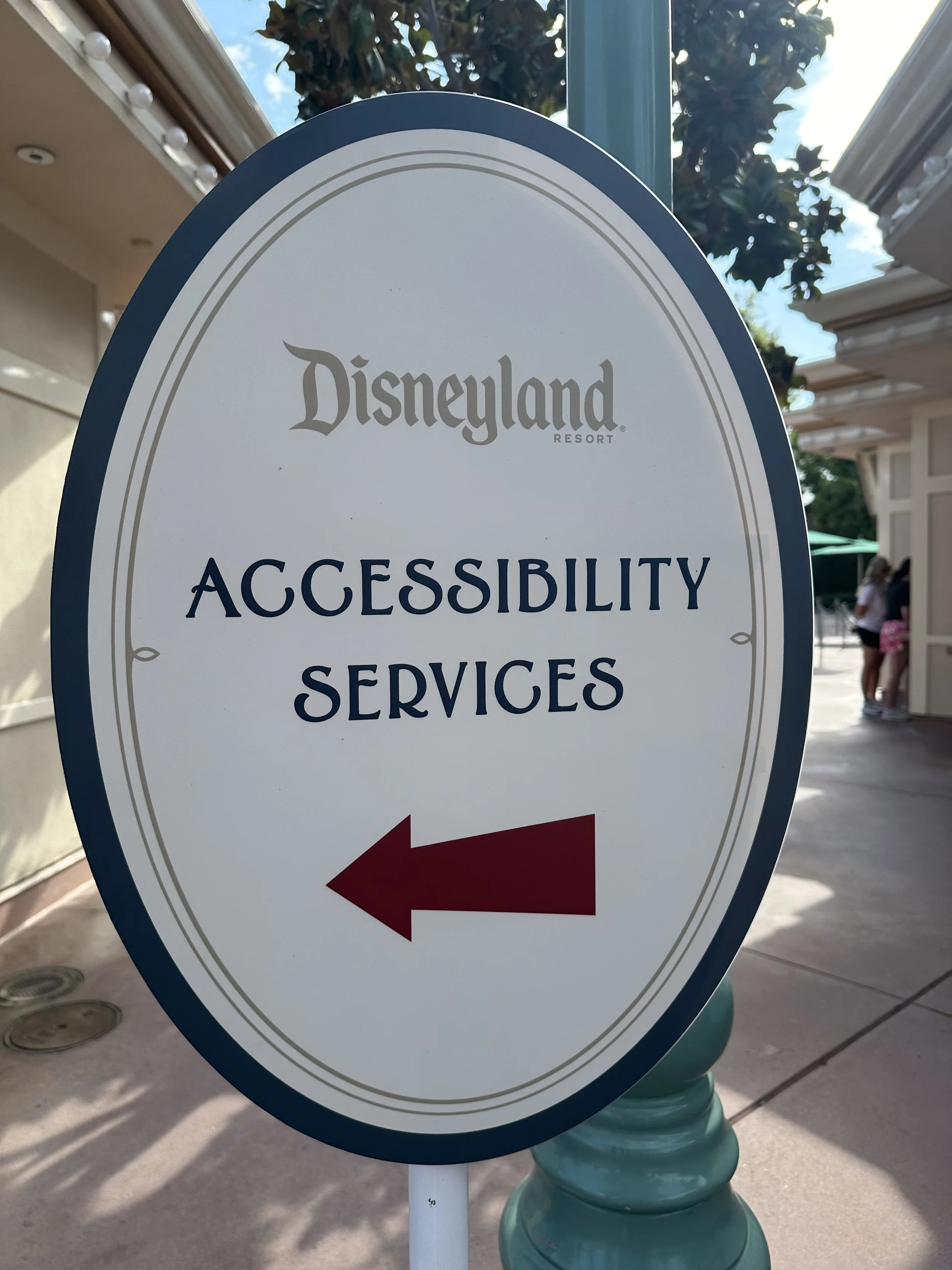large-off-white-and-blue-round-disneyland-accessibility-services-sign-at-the-disneyland-resort