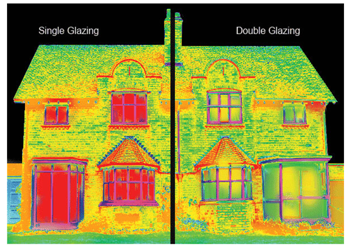 Infrared thermal image of a house, showing single glazing on the left side and double glazing on the right side, highlighting heat retention differences.
