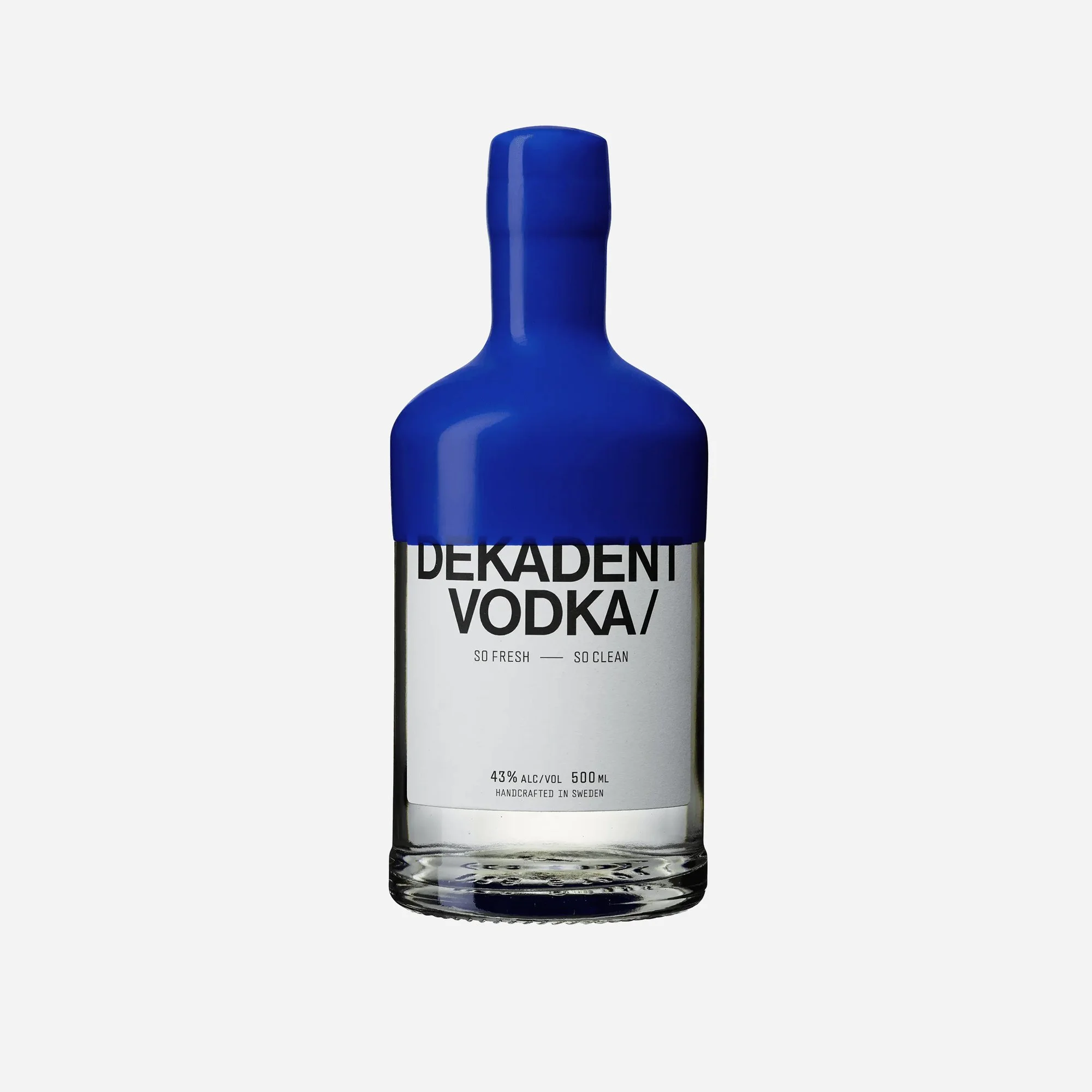 A tall clear glass bottle labeled 'Dekadent Vodka' with a blue cap, standing against a plain background.