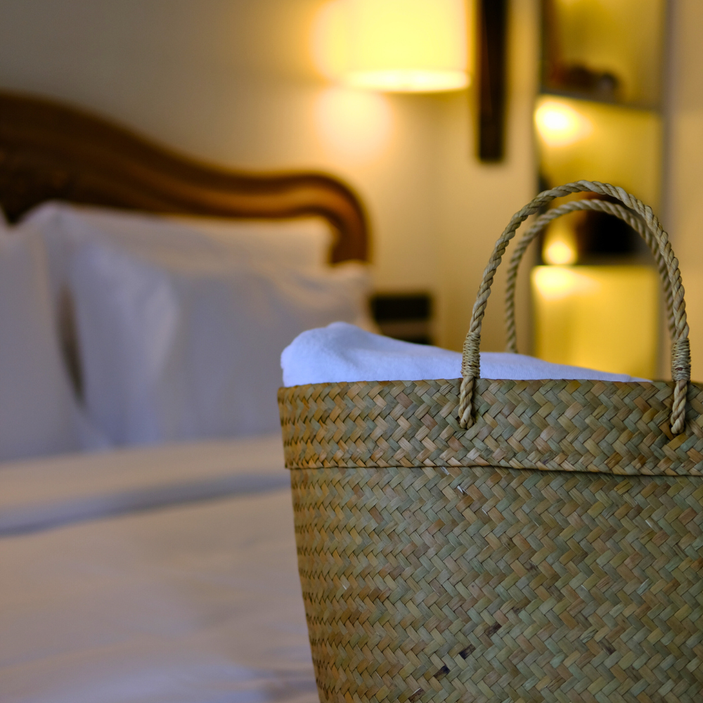Tung Yai basket by a luxurious bed in low light, exuding a warm and peaceful bedroom ambiance.