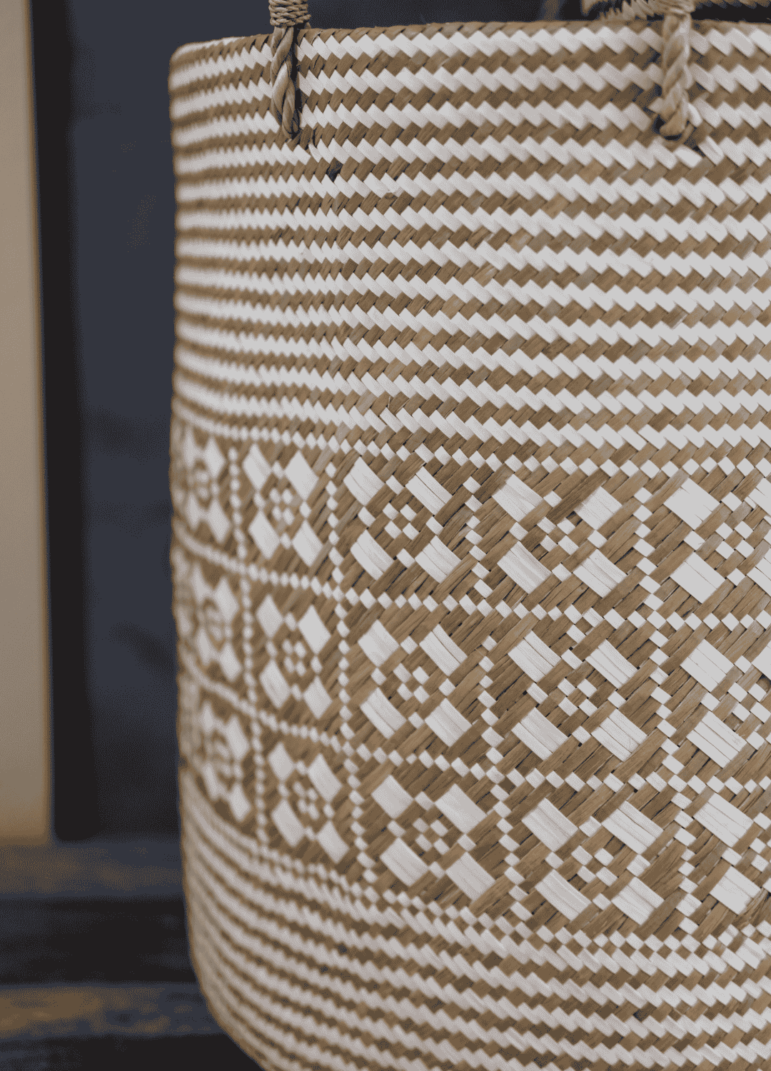 Side view of the basket’s bold zigzag and diamond weave patterns in natural and cream tones.