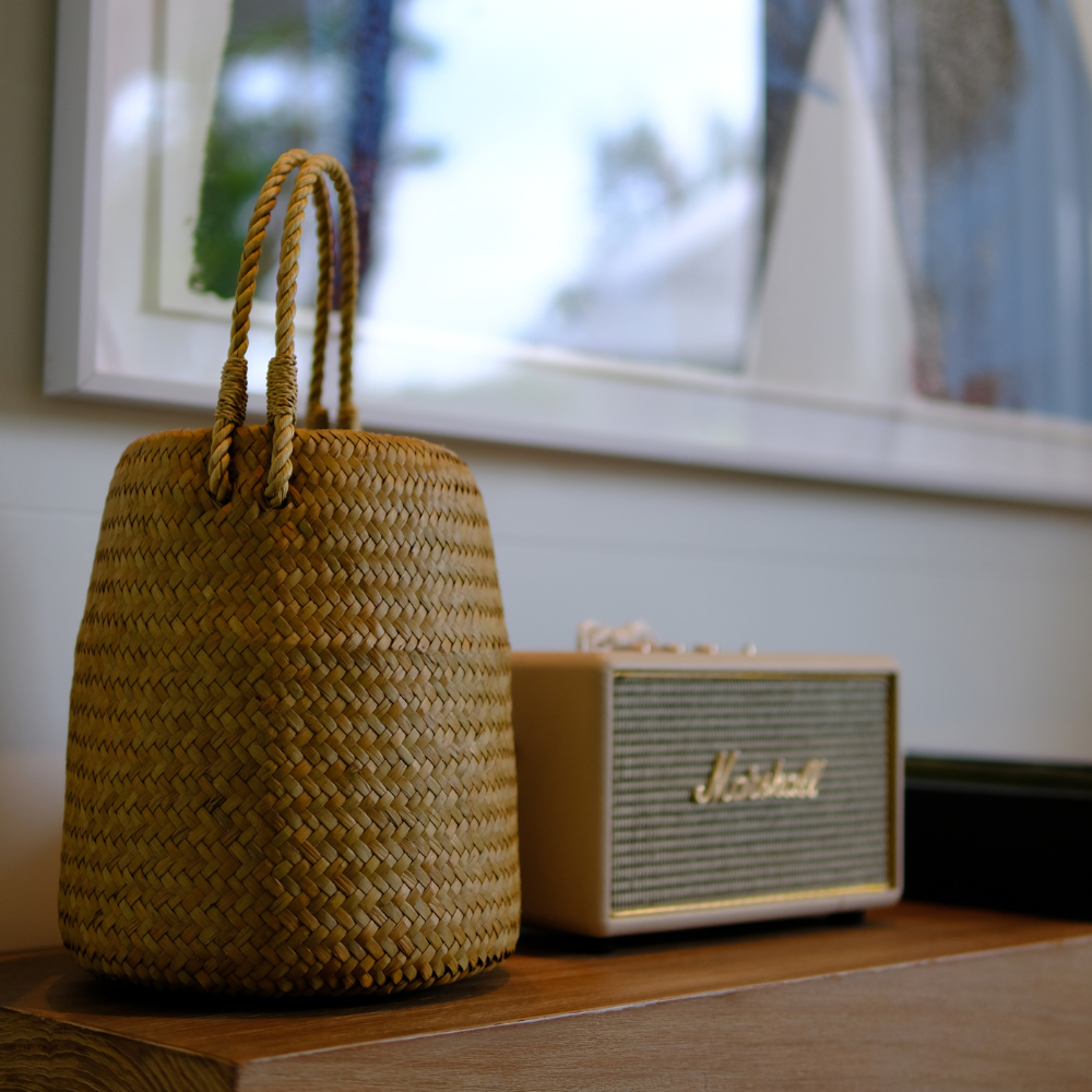 Toong Nom basket styled by a speaker on a windowsill, natural daylight streaming in.
