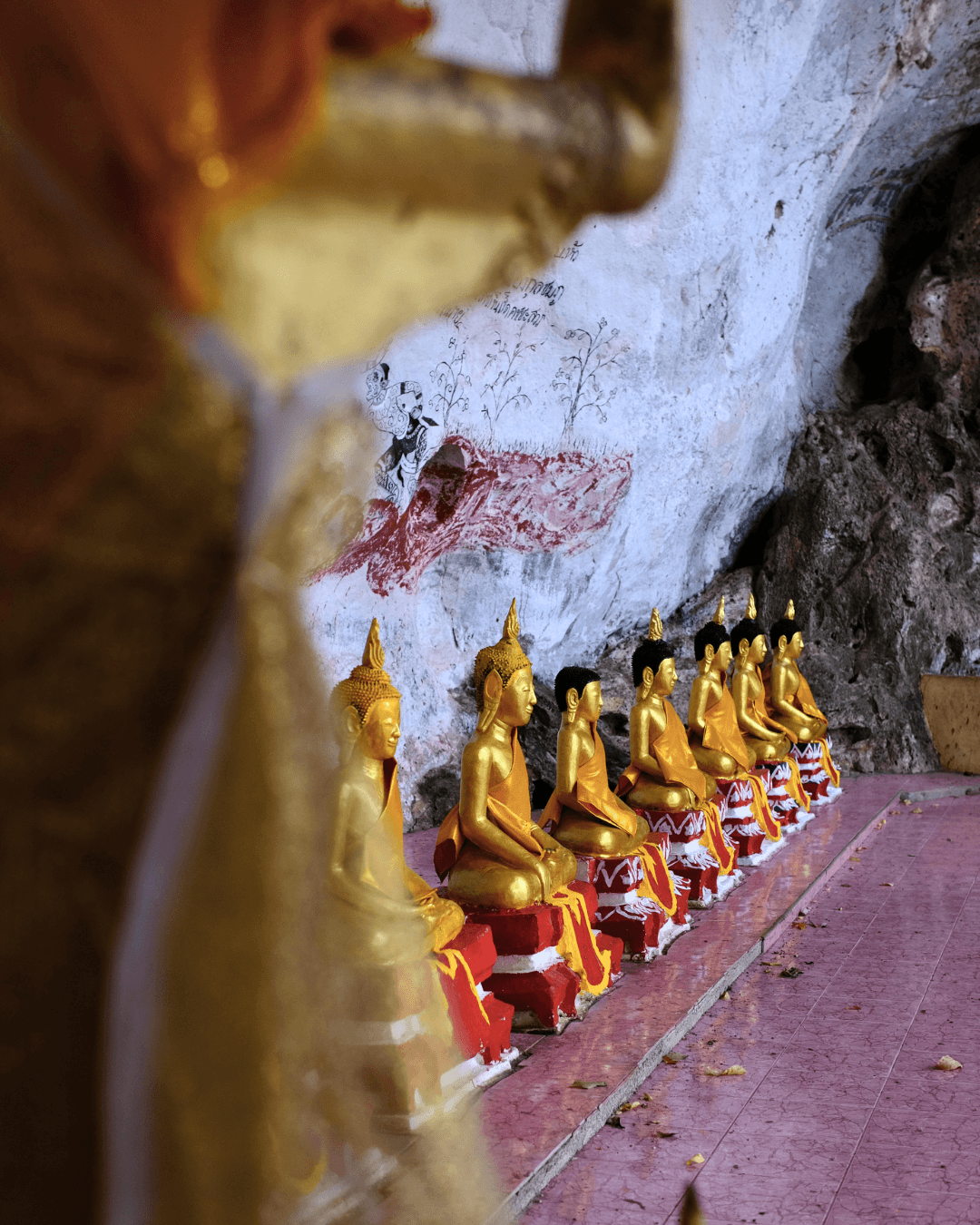 Small figures inside Tham Phra Chaison.