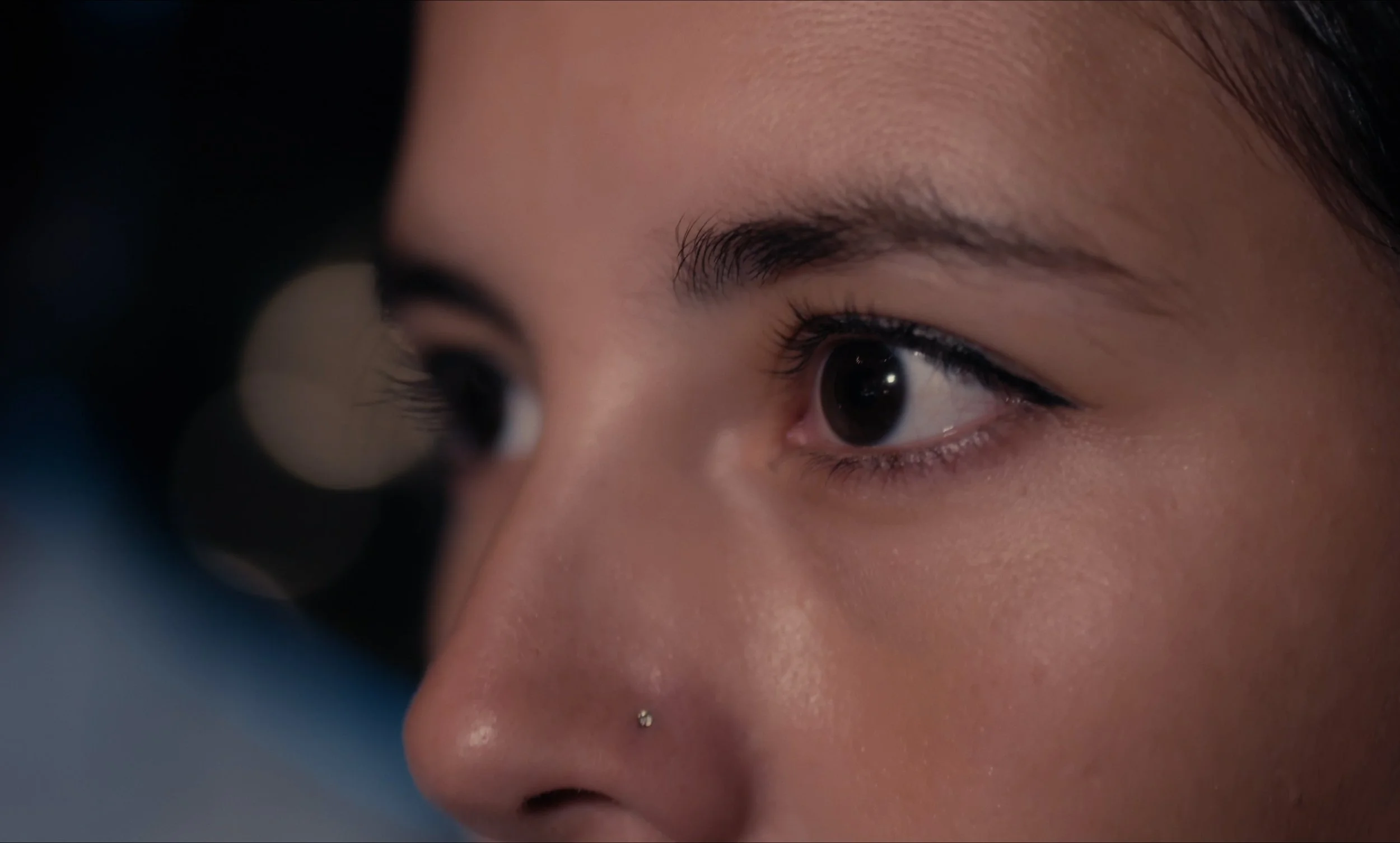 Primer plano de los ojos de una persona con un piercing en la nariz.