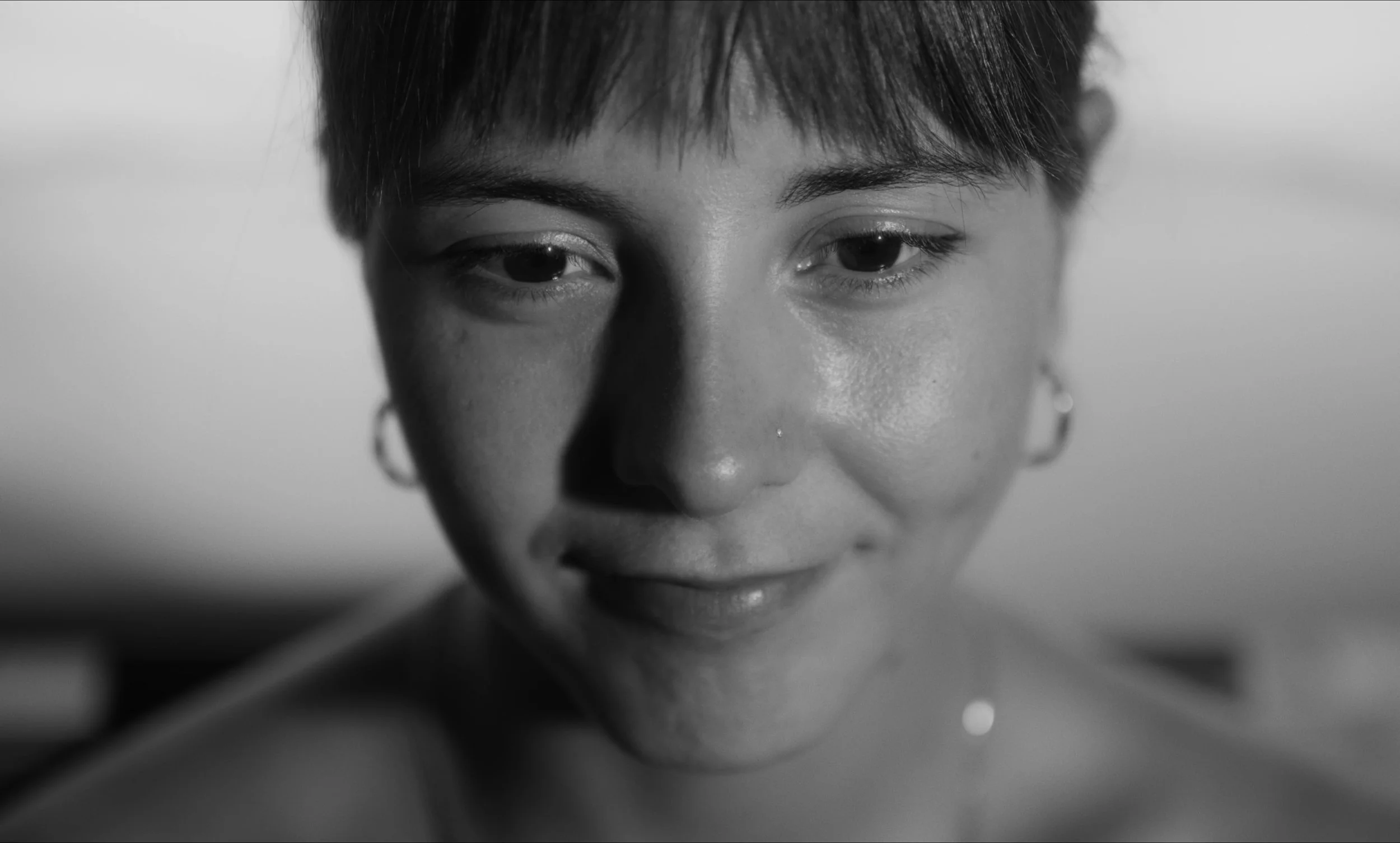 Retrato en blanco y negro de una persona sonriendo ligeramente.