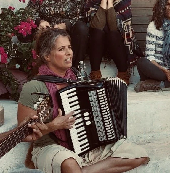 People sitting around a fire at night and sing, Singing Circle