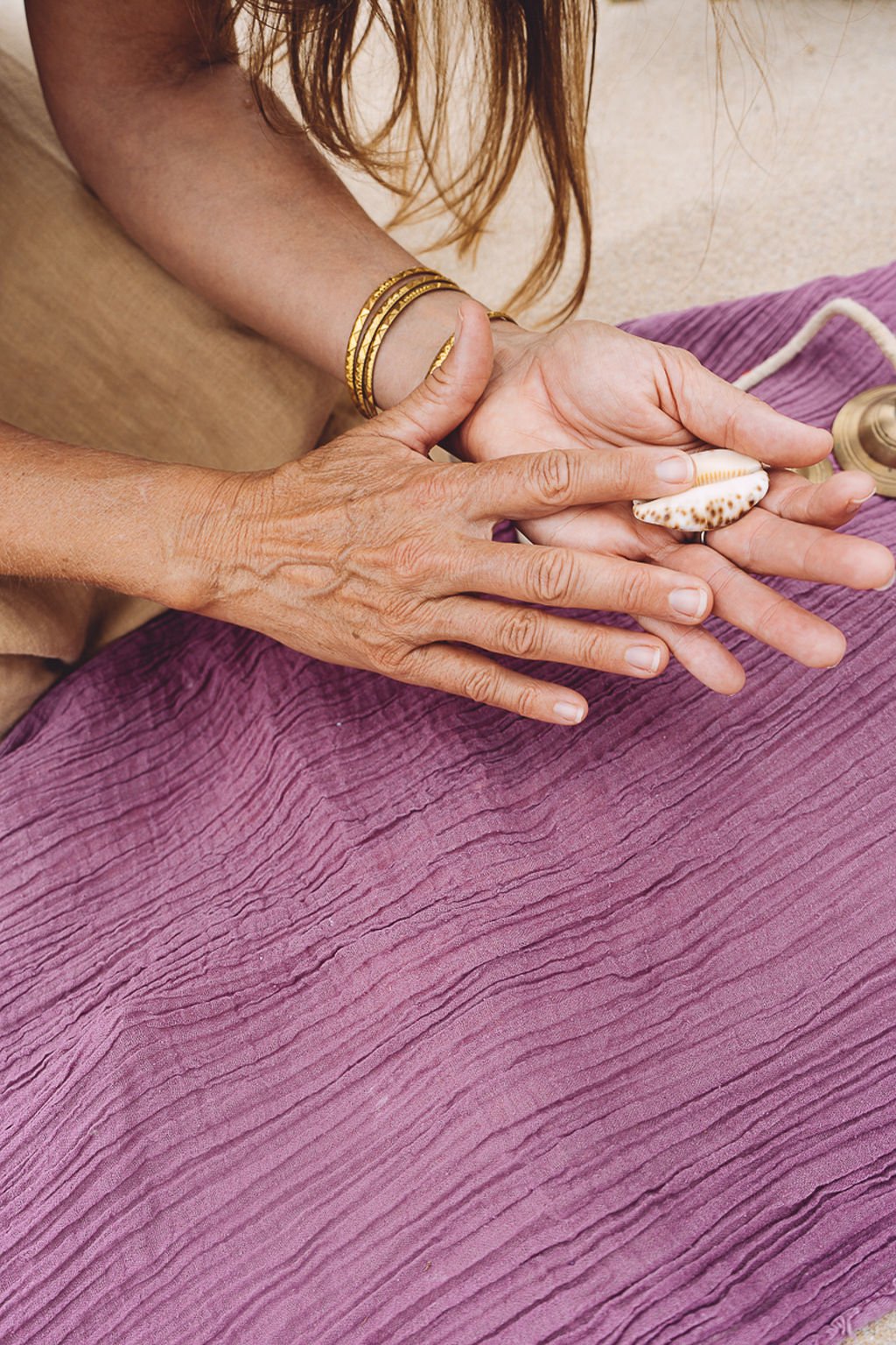 Women touching a vulva shaped shell