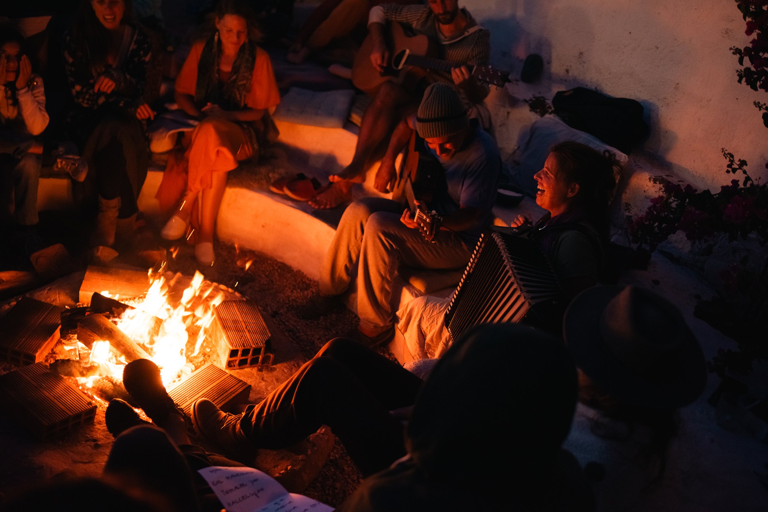 People sitting around a fire at night and sing, Singing Circle