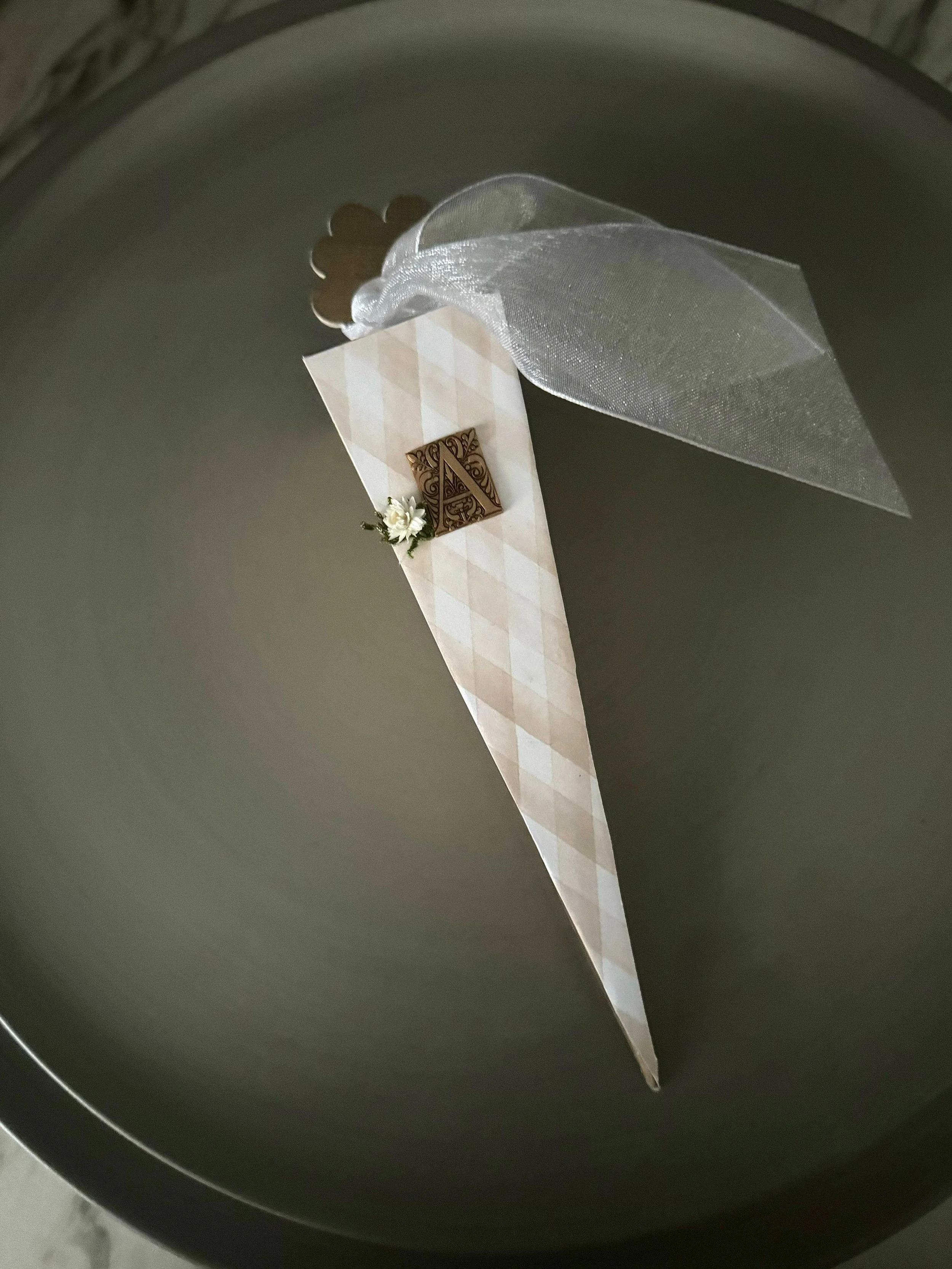 The inside of a black air fryer with a parchment paper liner that has a decorative floral and letter design on it.