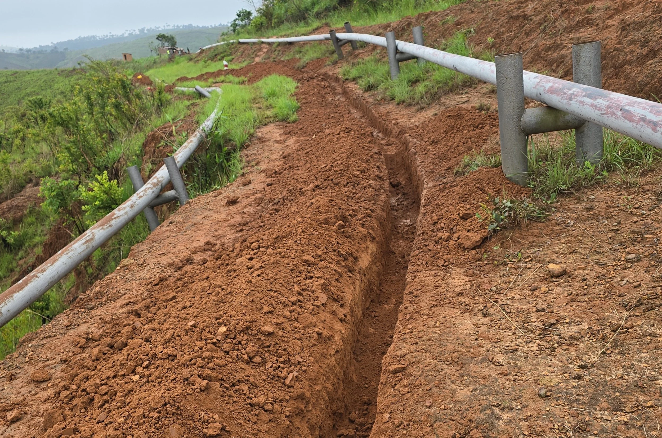 A trench in the ground ready to lay a duct and fibre optic cables