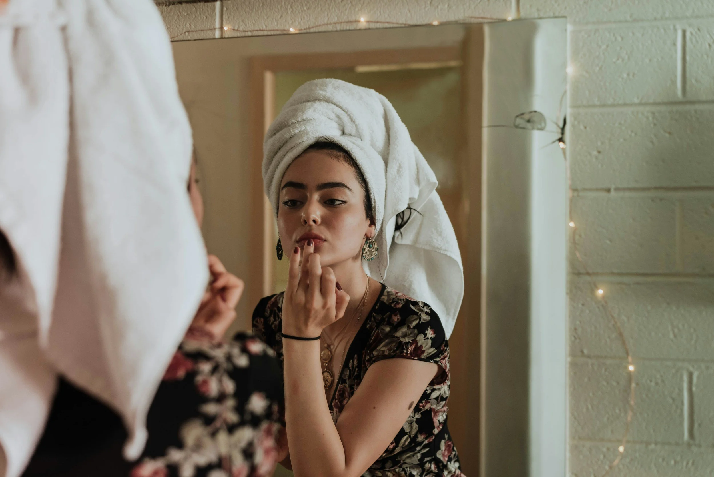 Woman examining uneven skin texture, fine lines and sun damage before skin treatment