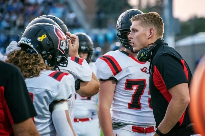 A coach talking to his football team.