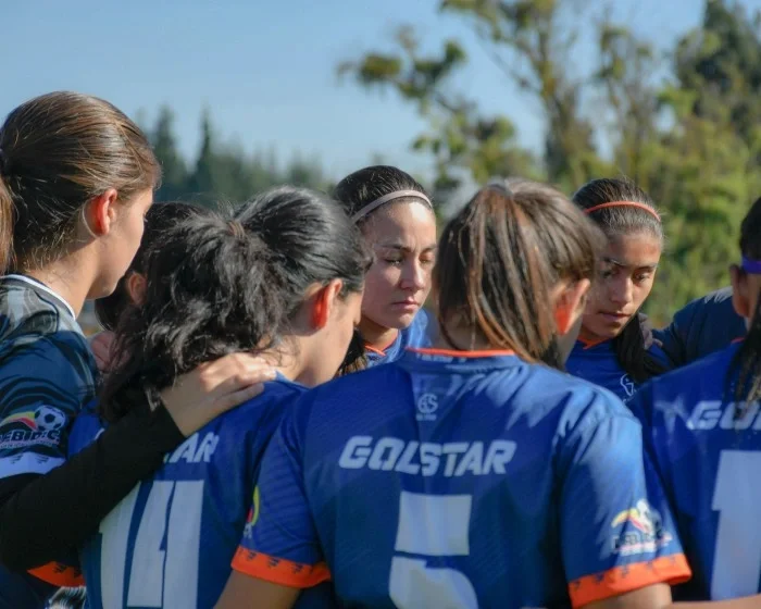 A women's soccer team in a huddle.
