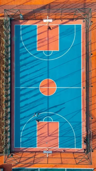 An orange and blue outdoor basketball court from above.