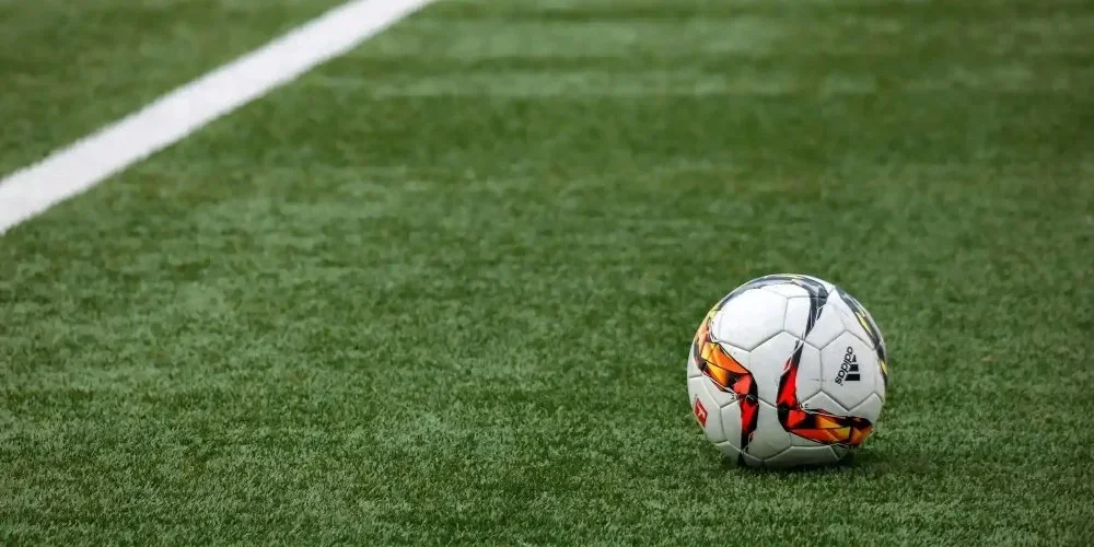 A soccer ball resting on an outdoor field.