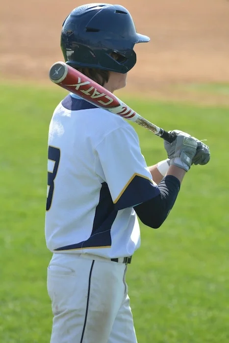 A baseball player getting ready to go up to bat.