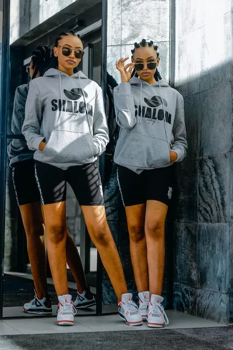 Two teen girls with athletic clothes on, posing confidently.