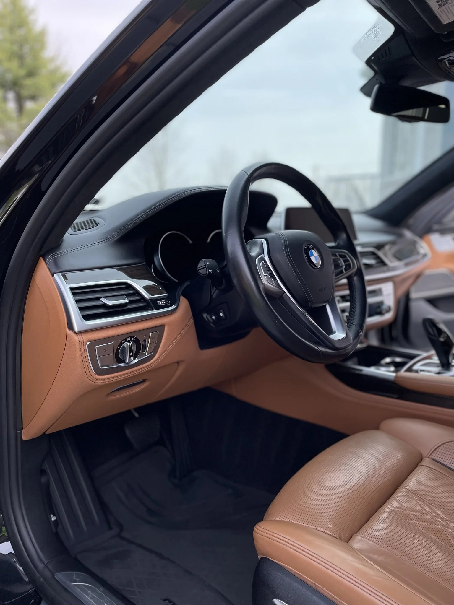 Interior of car with brown leather and black steering wheel