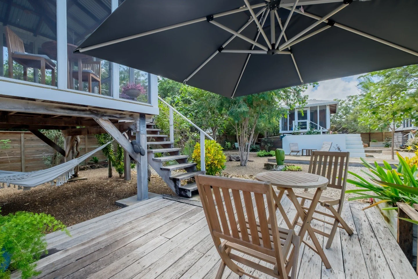 Three separate 300-square-foot casitas, each fully independent, connected by wooden pathways through over 20 species of mature landscaping &mdash; a botanical garden property with a central plunge pool and solar-powered feature lighting that comes on