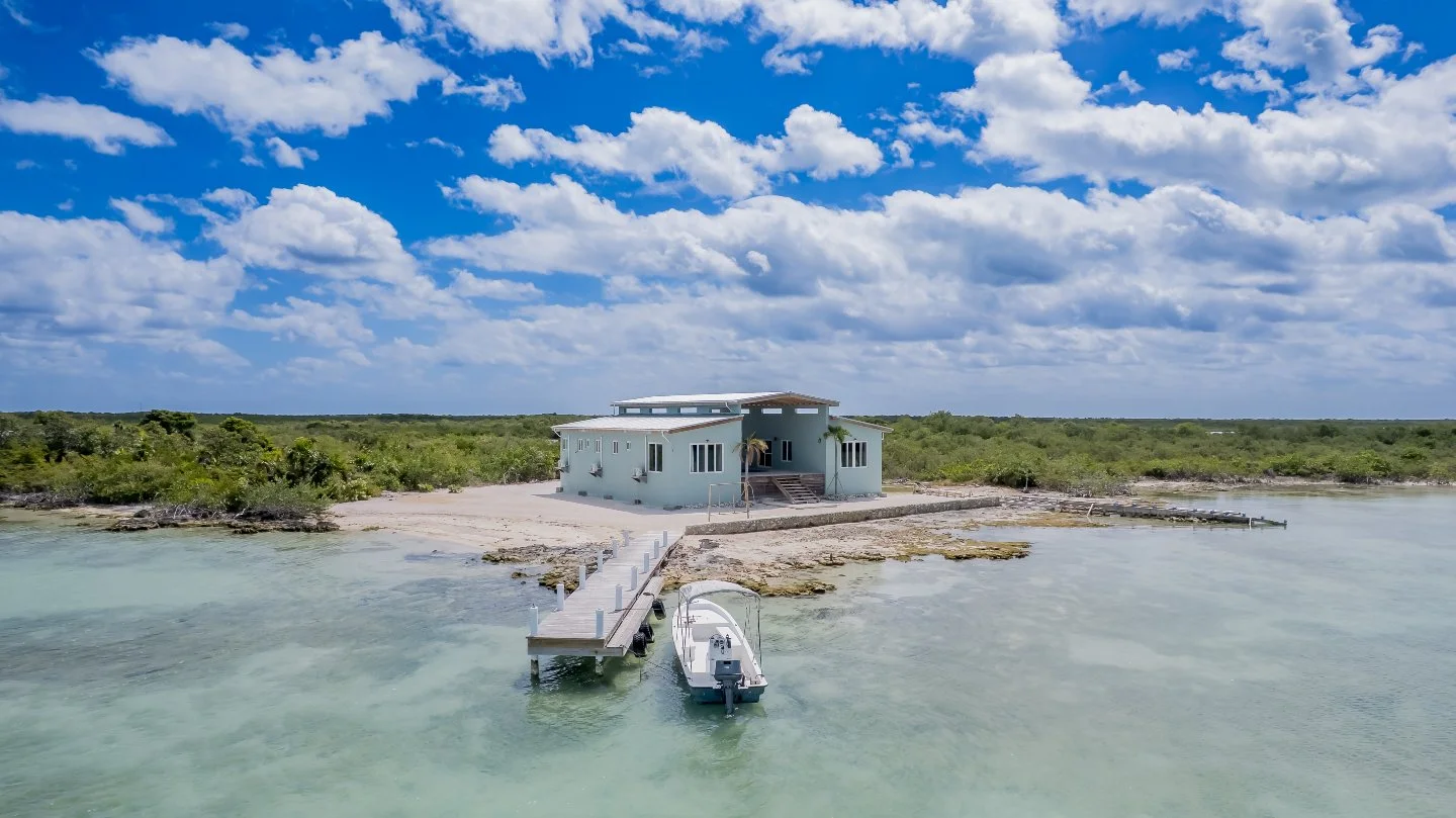 Boat access only. That's the whole context for this property. No road, no drive-by traffic, no neighbors close enough to matter. Just 186 feet of west-side beachfront, nearly an acre of lot, and a 944-square-foot covered wood deck where the sun goes 