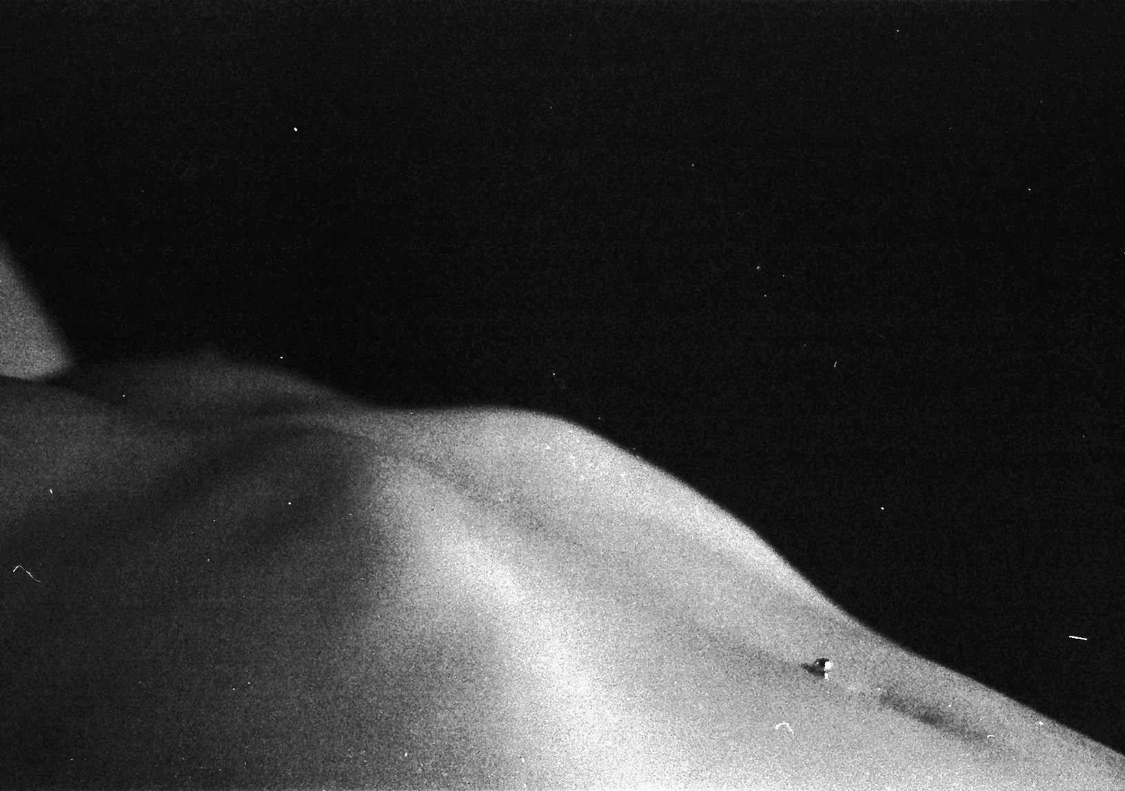 Black and white photo of sand dunes under a starry night sky.