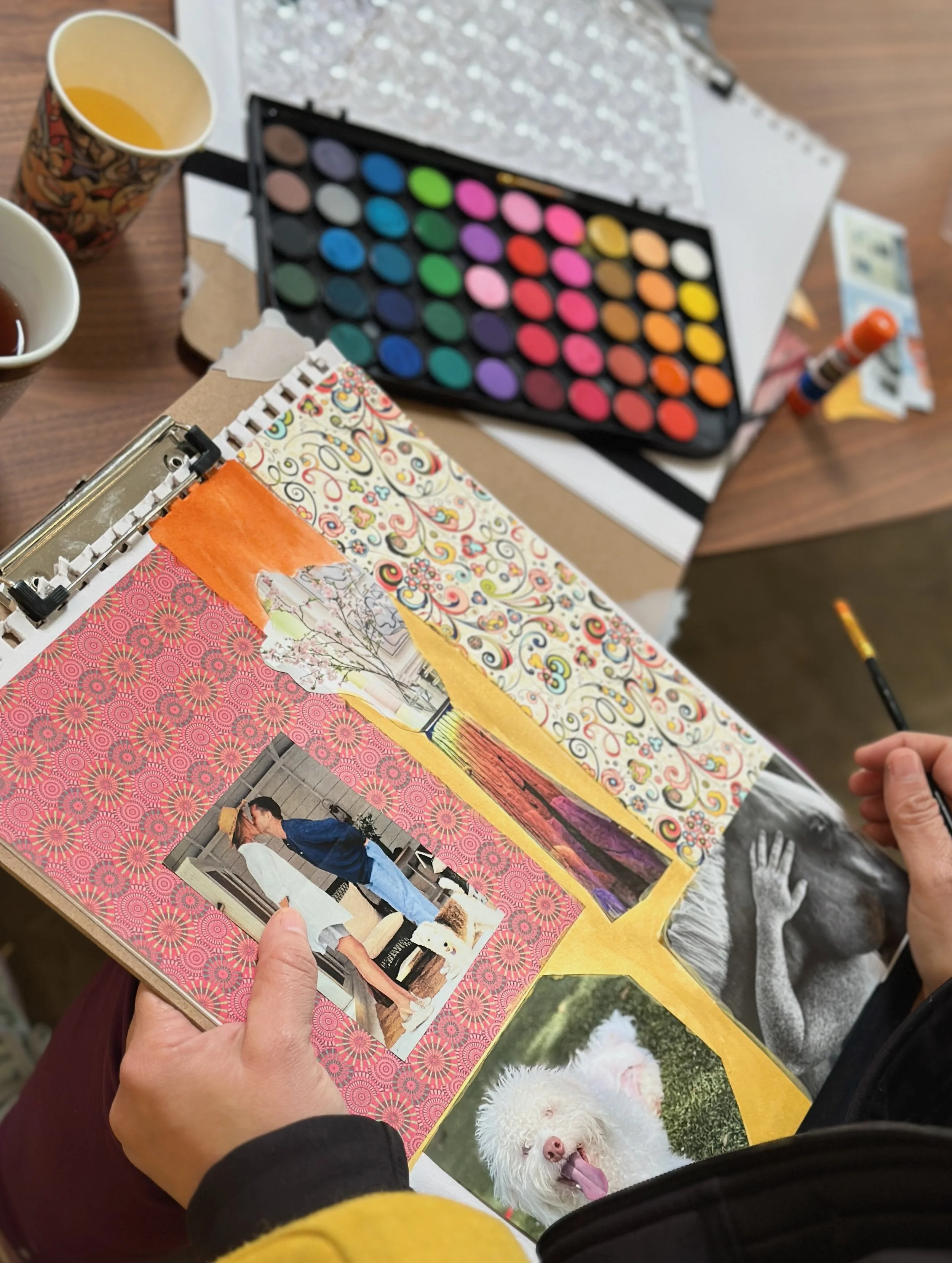 Art therapy in progress showing hands working with creative materials, demonstrating the therapeutic process of art-making.