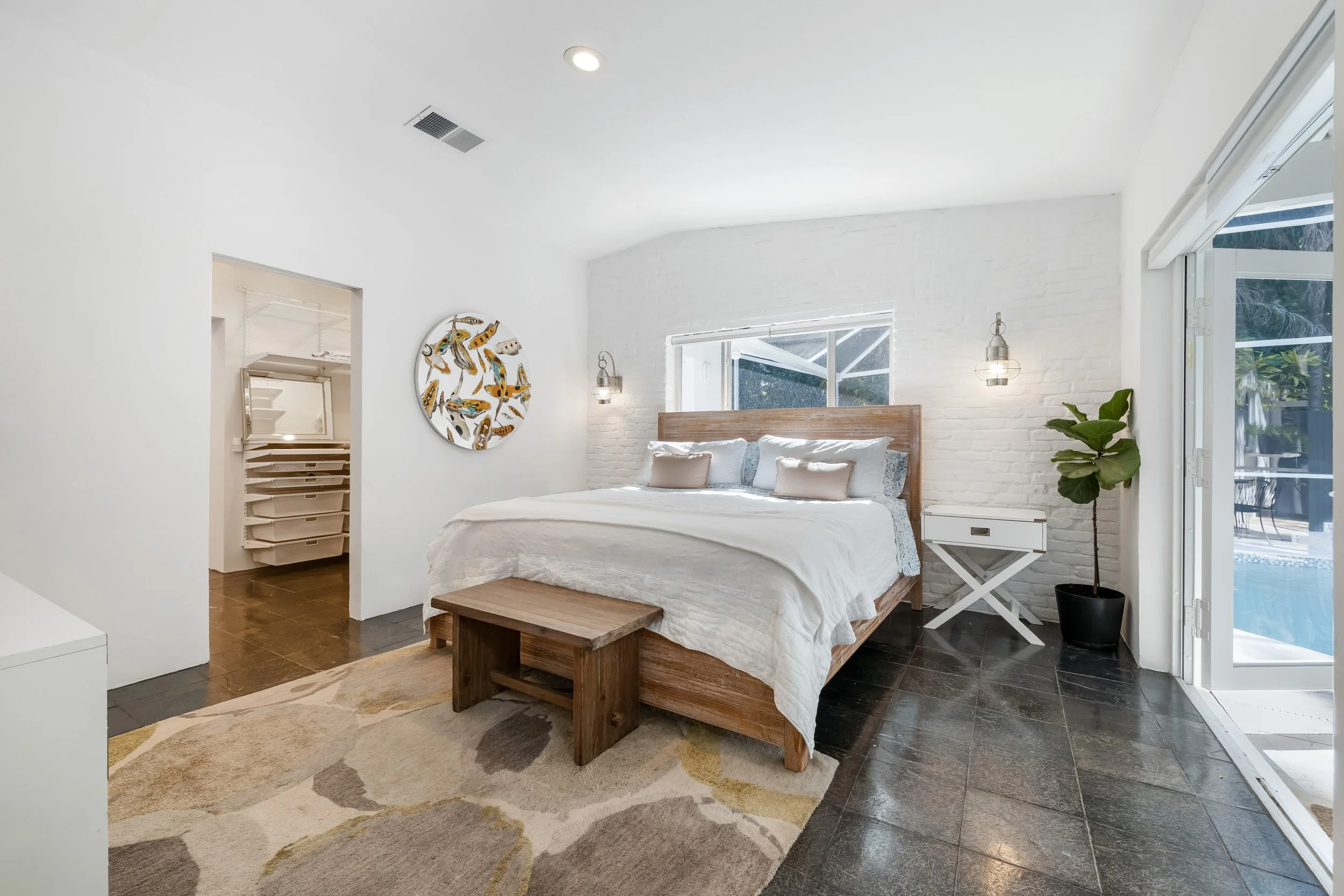 South Miami luxury home primary bedroom with walk-in closet and direct access to the private pool.