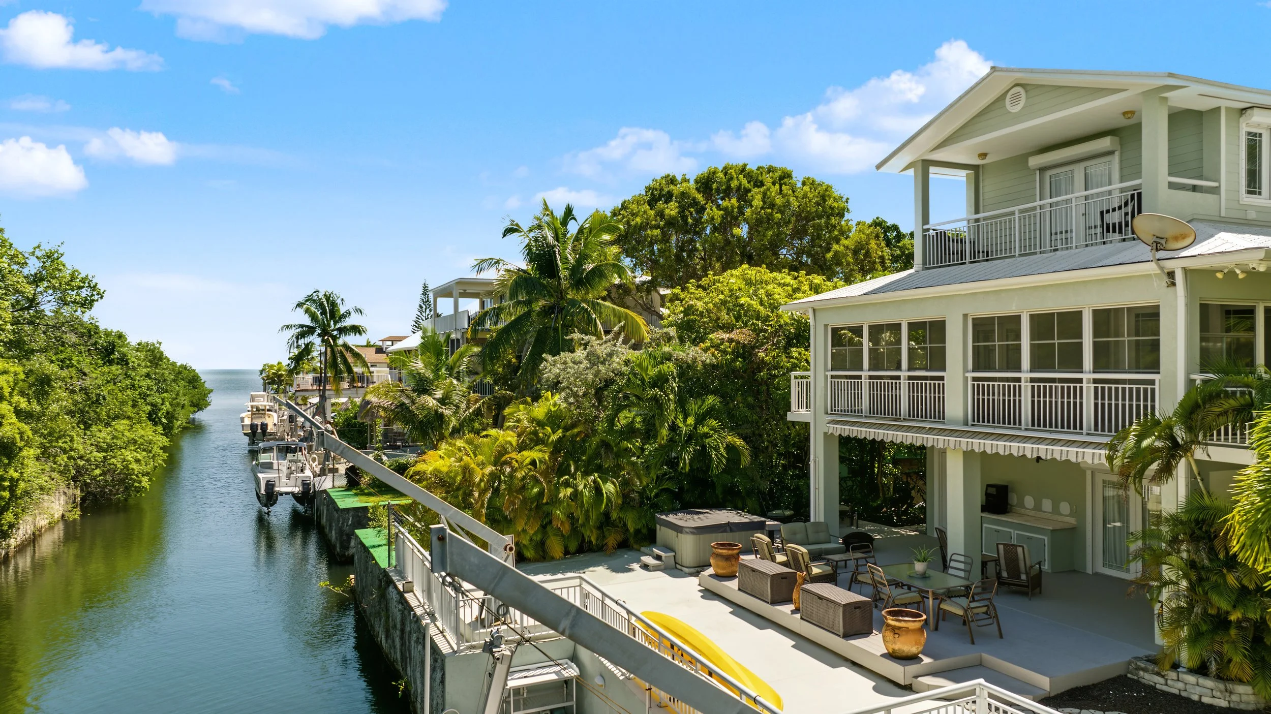 Aerial view of a Key Largo waterfront home with canal access, dock and tropical landscaping