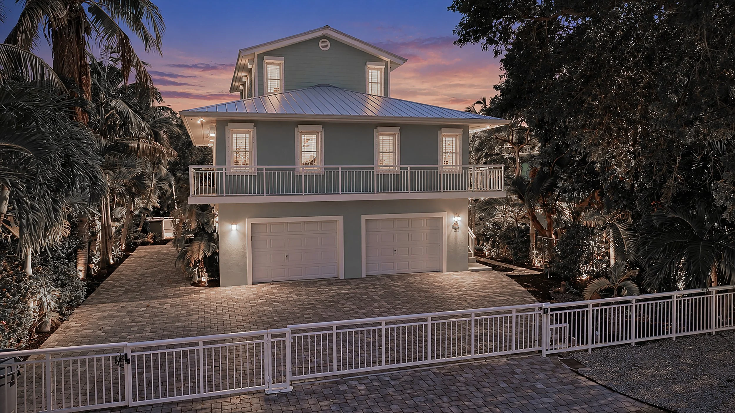 Twilight exterior of a luxury Key Largo home surrounded by tropical landscaping in the Florida Keys I