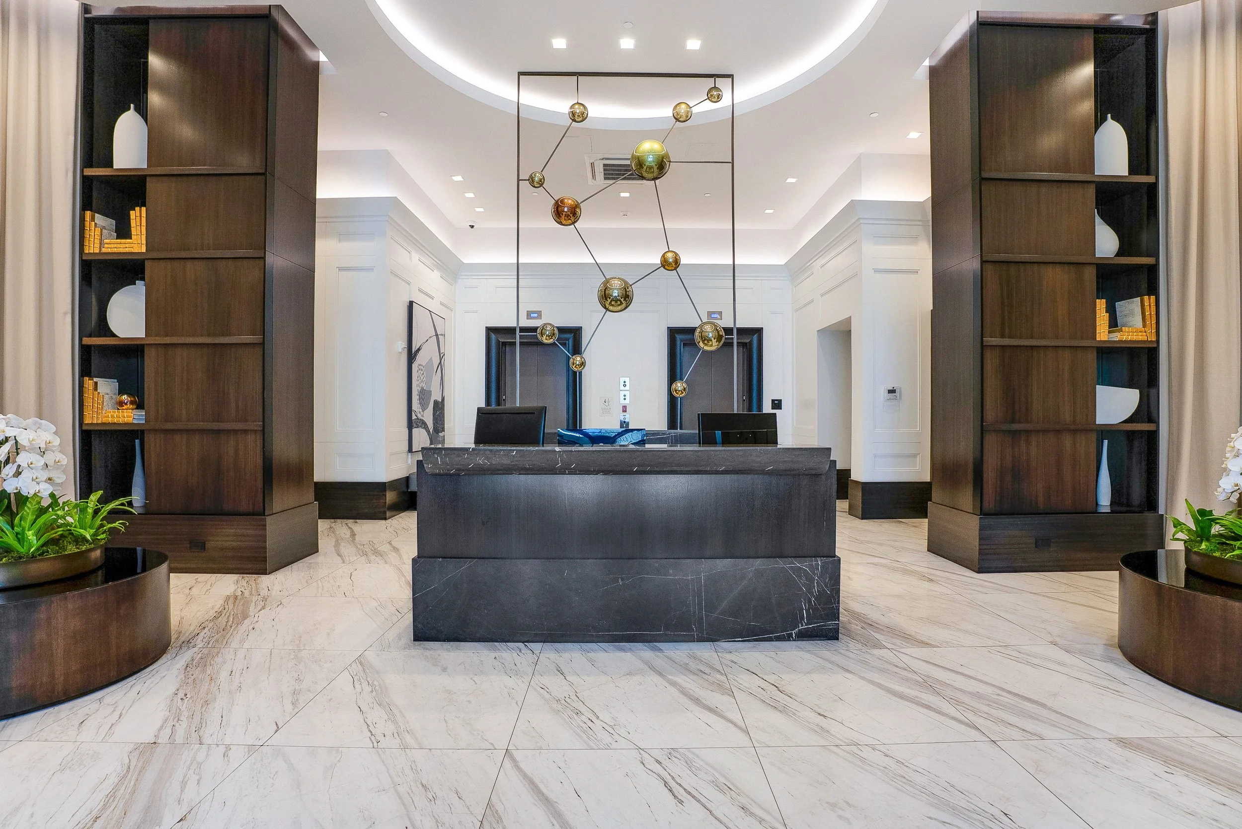 Luxury condominium lobby with modern reception desk and contemporary lighting in Coral Gables, Florida.