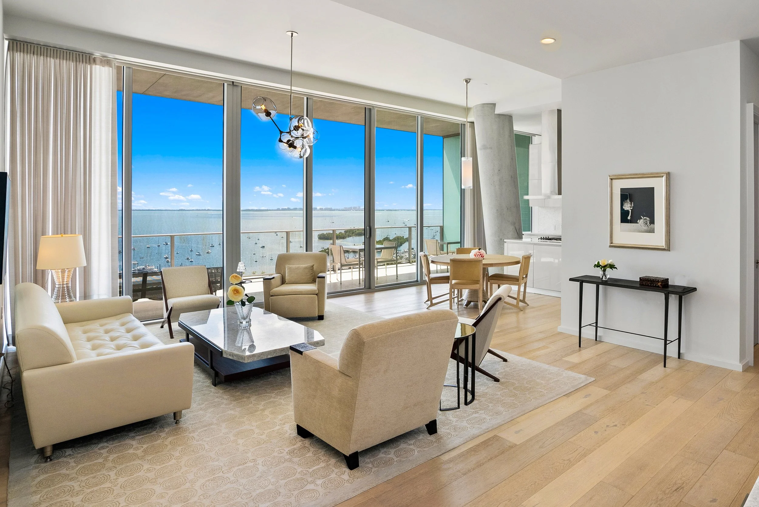 Luxury Coconut Grove condo living room featuring floor-to-ceiling windows, an open-concept design, private balcony and expansive views of Biscayne Bay.