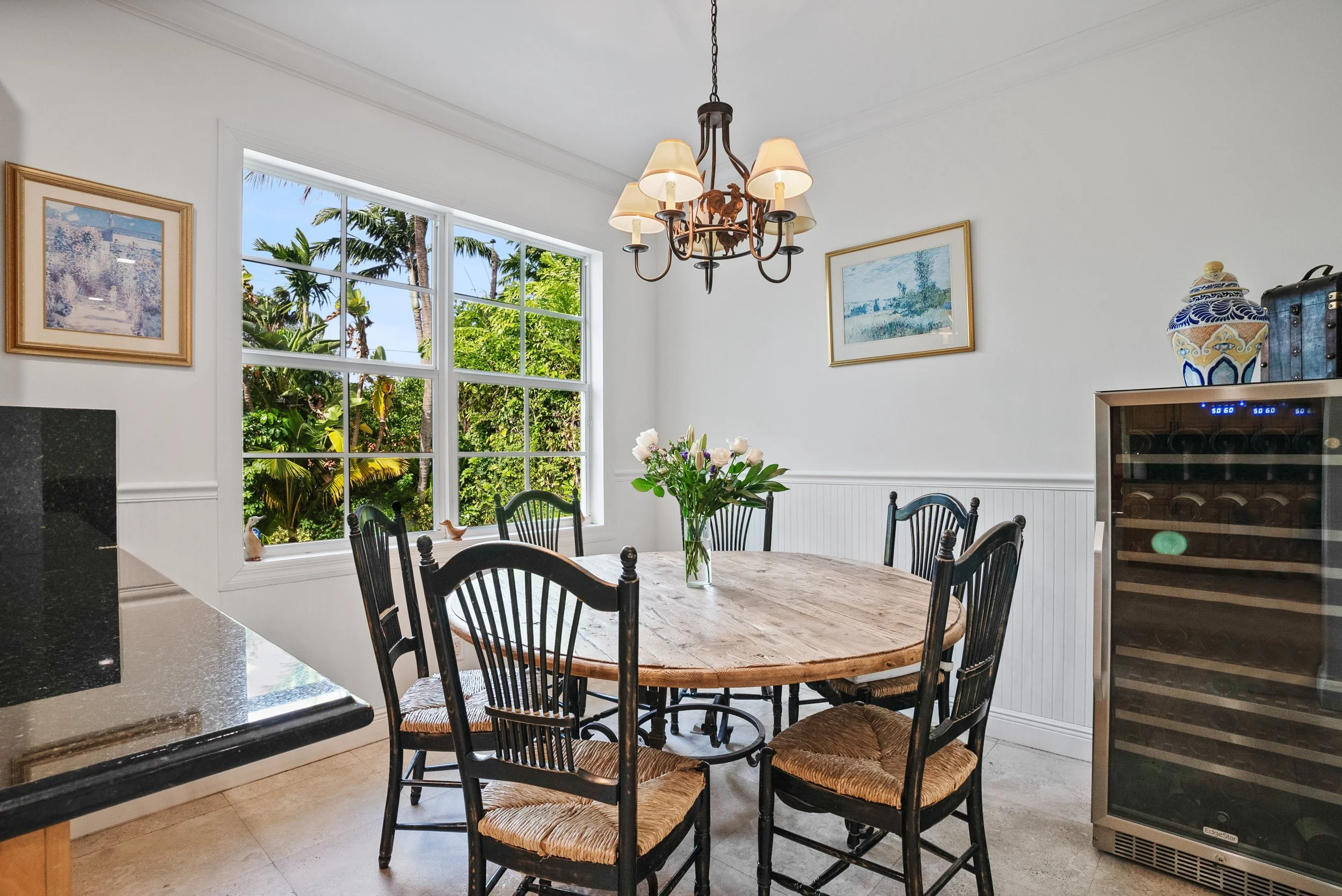Key Biscayne home dining room with large window overlooking tropical landscaping.
