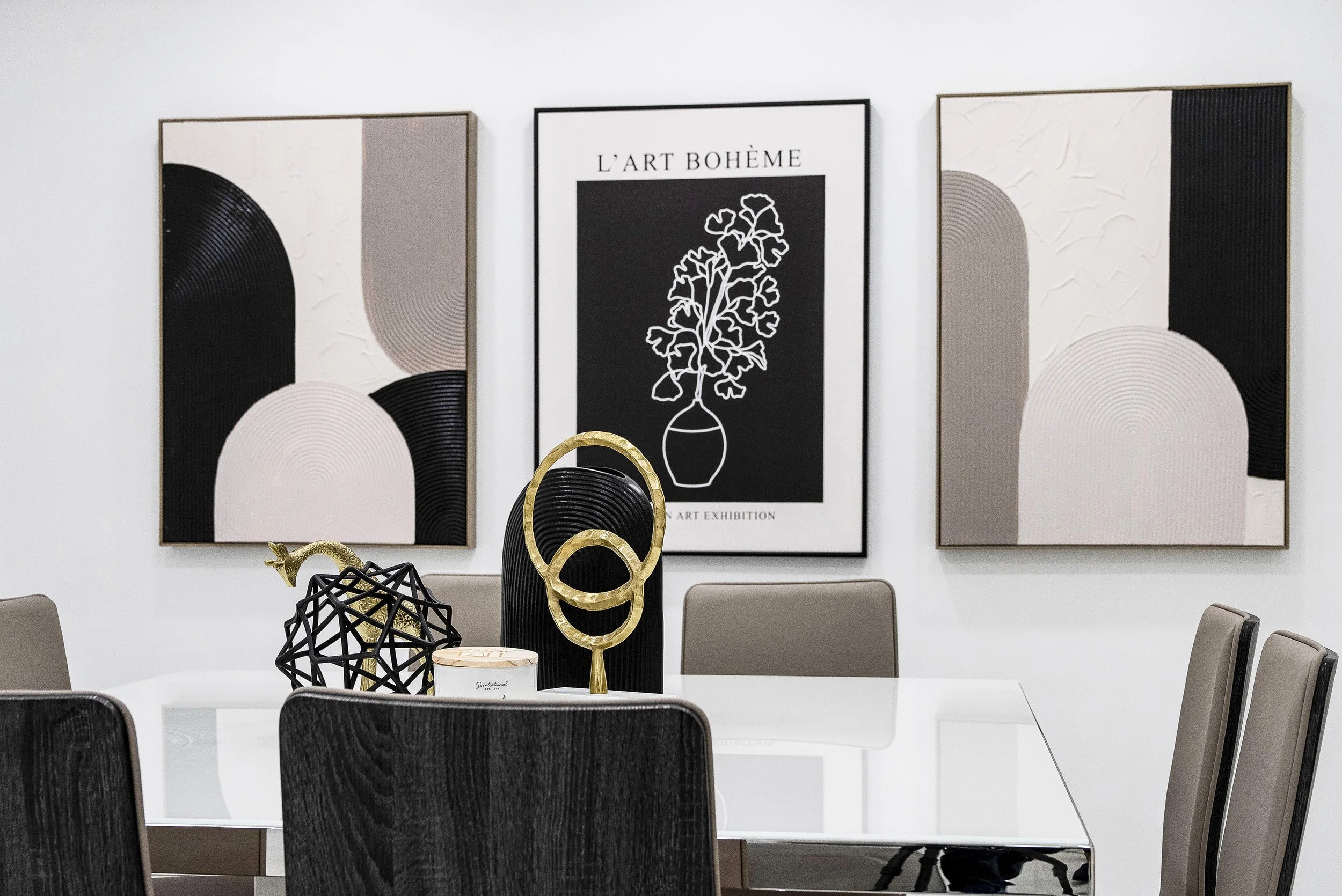 Professional real estate photography of a modern luxury dining room in Fort Lauderdale, Florida, featuring a glossy white dining table, contemporary upholstered chairs, black-and-white abstract wall art, and elegant gold decorative accents.
