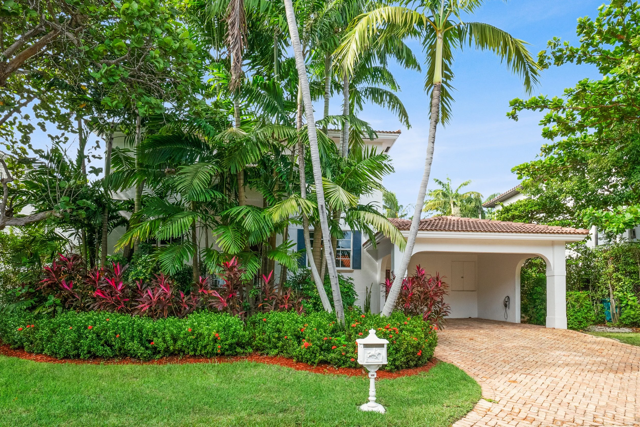 Key Biscayne home exterior with lush tropical landscaping and palm trees.