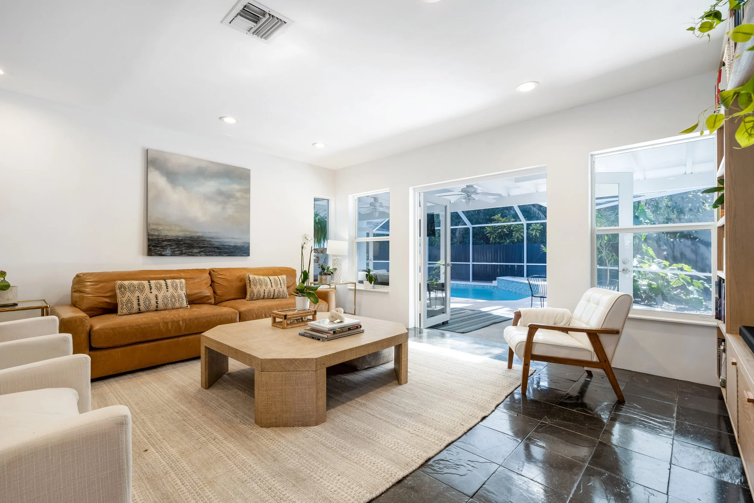 South Miami luxury home living room with French doors opening to a private pool and outdoor living area.